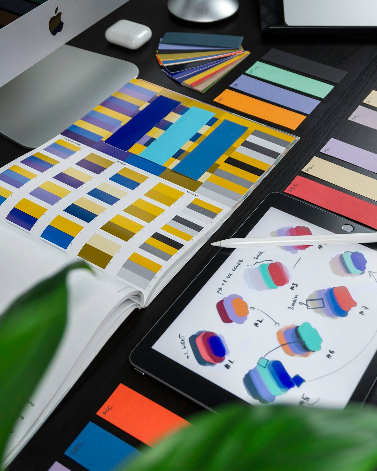 Flat lay of brand identity design process showing logo sketches, color samples, and design tools